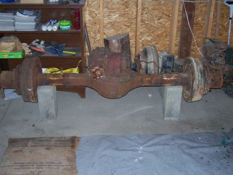 1979 Ford F-150 - A heavily rusted rear axle assembly is shown supported by concrete blocks in a garage setting.