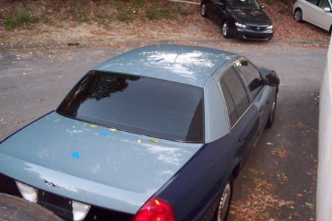 2001 Ford Crown Victoria - A two-tone Ford Crown Victoria is parked outdoors, with another car visible in the background.