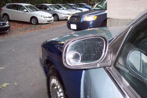 2001 Ford Crown Victoria - A 2001 Ford Crown Victoria is parked on asphalt, with other vehicles visible in the background.