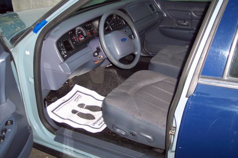 2001 Ford Crown Victoria - The interior of a 2001 Ford Crown Victoria police car, the dashboard, steering wheel, and front seats.