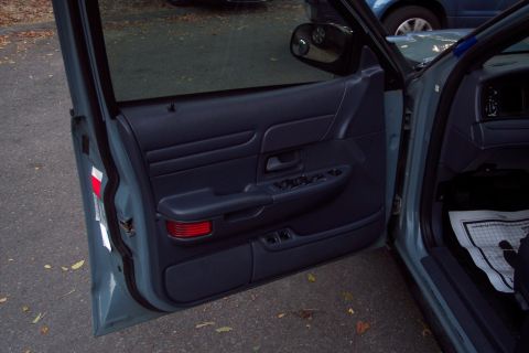 2001 Ford Crown Victoria - Interior view of a car's driver side door panel and part of the dashboard.