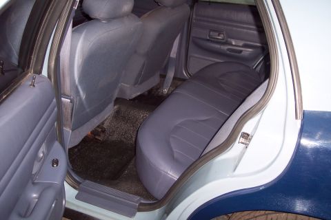 2001 Ford Crown Victoria - Rear interior view of a 2001 Ford Crown Victoria, highlighting the blue cloth seats and door trim.