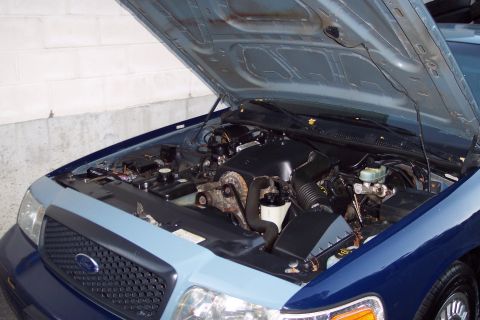 2001 Ford Crown Victoria - Engine compartment of a 2001 Ford Crown Victoria, with the hood fully open for access.