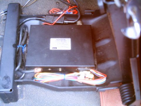 1995 Ford Bronco - An electronic module and wiring harness are visible under the seat of a vehicle.