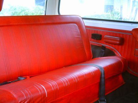1995 Ford Bronco - Interior view of a red vinyl bench seat and door panel.