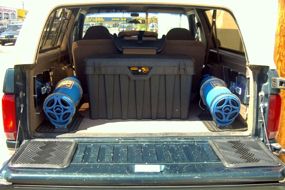 1992 Ford Bronco interior showing two blue speakers and a black toolbox in the cargo area