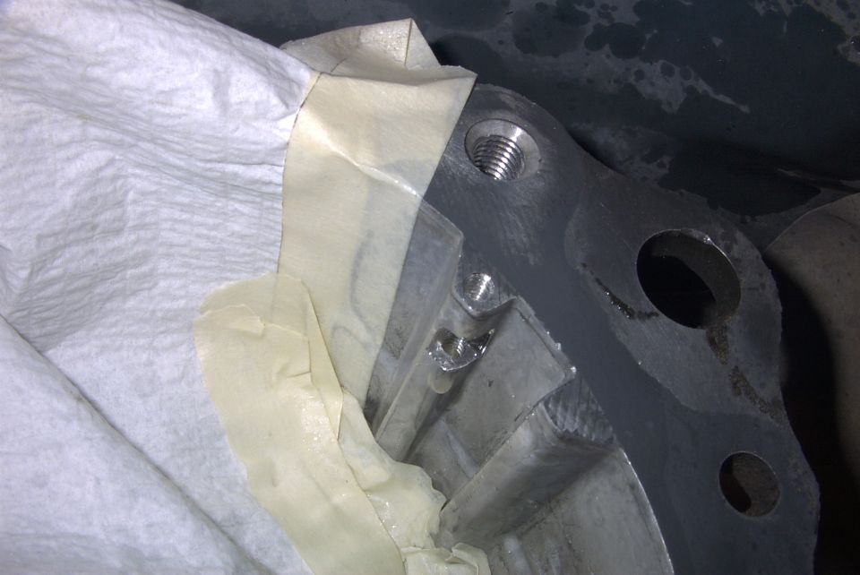 Close-up of a metal engine part covered with tape and paper towels