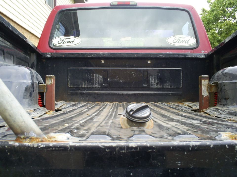 1994 Ford F-250 pickup truck bed with two Ford oval stickers on the rear window