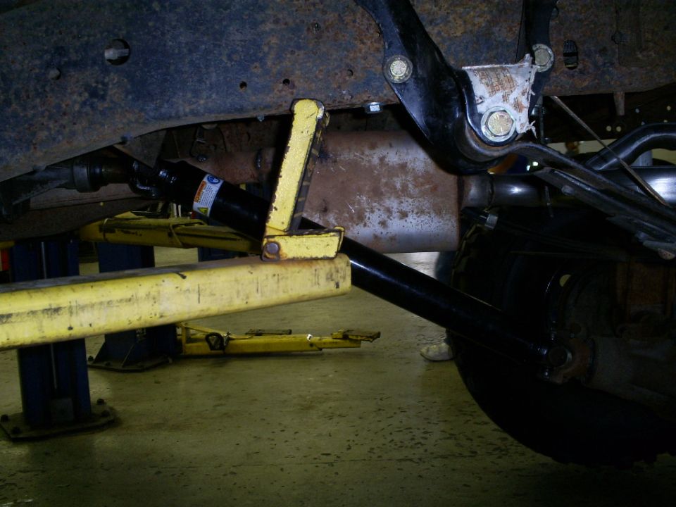 1994 Ford F-250 undercarriage, showing suspension and exhaust system, with a hydraulic jack
