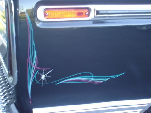 1979 Ford F-250 - A close-up of a 1979 Ford F-250's fender shows custom pinstriping and a portion of the chrome bumper.