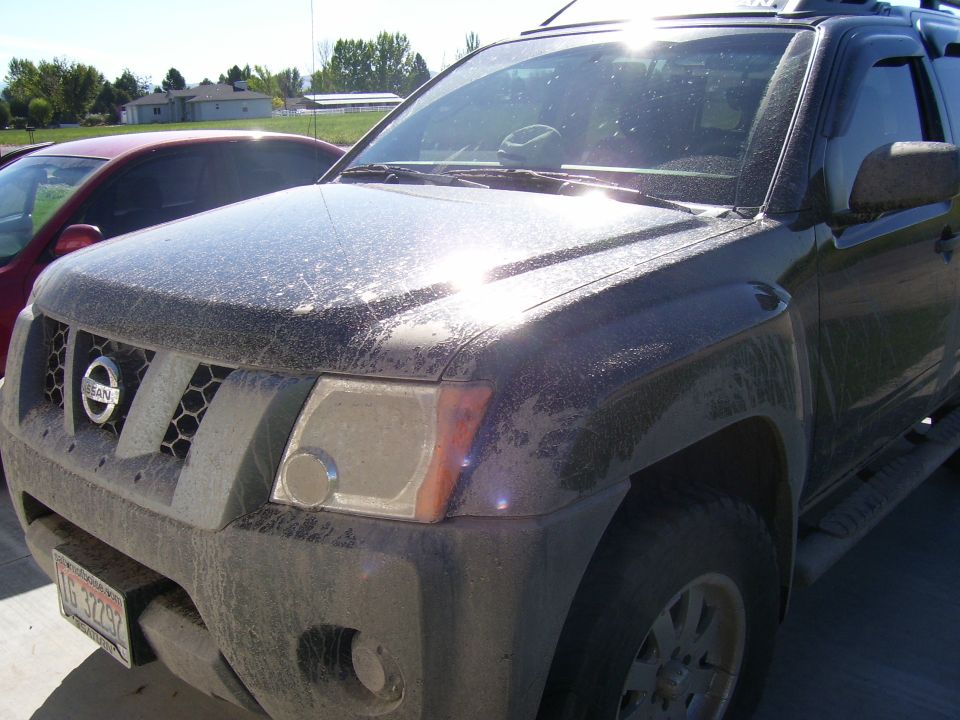 Dust-covered dark Nissan Xterra SUV, front three-quarter view, with Idaho license plate