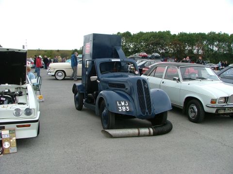 2001 Ford Fiesta - A vintage dark blue truck with a boxy cargo area is displayed at an outdoor event with other vehicles.