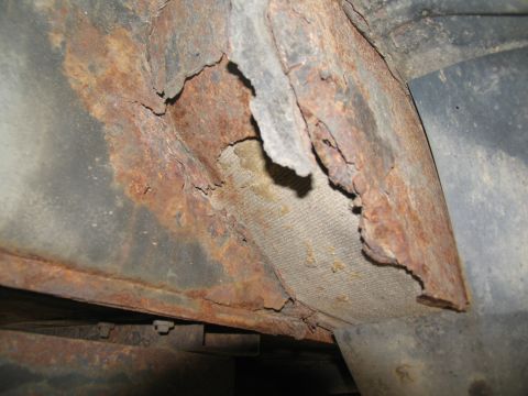 1995 Ford C-350 (Centurion Conversions) - Close-up of severely corroded metal structure, possibly part of a vehicle's undercarriage.