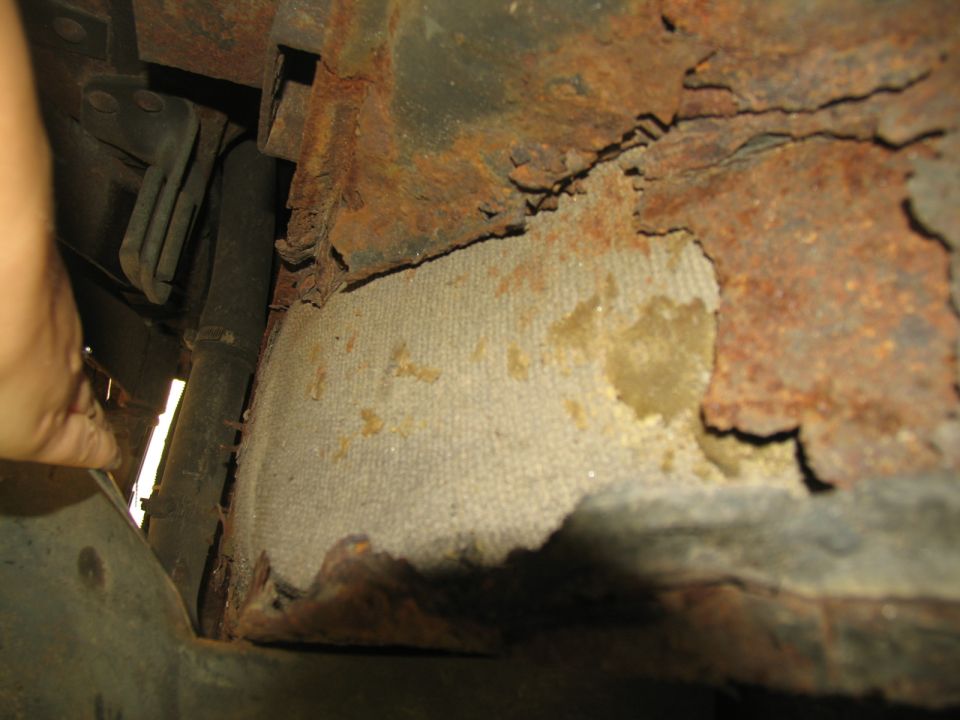 Rusted frame and undercarriage with exposed insulation