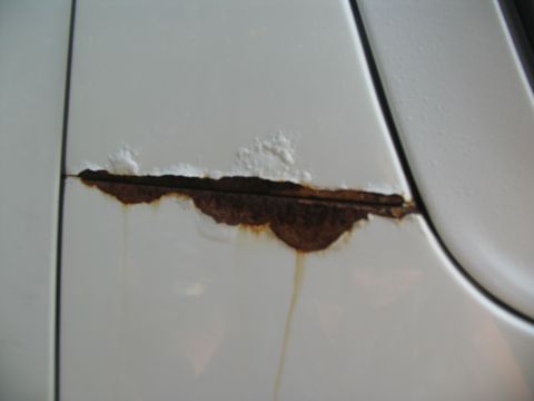 1995 Ford C-350 (Centurion Conversions) - Rust is visible on a white vehicle panel, indicating damage.