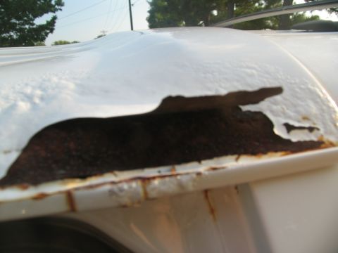 1995 Ford C-350 (Centurion Conversions) - Severe rust damage is visible on the white roof of a vehicle, with paint peeling away to reveal corroded metal underneath.