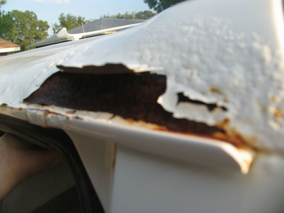 Close-up of white vehicle roof showing significant rust and peeling paint