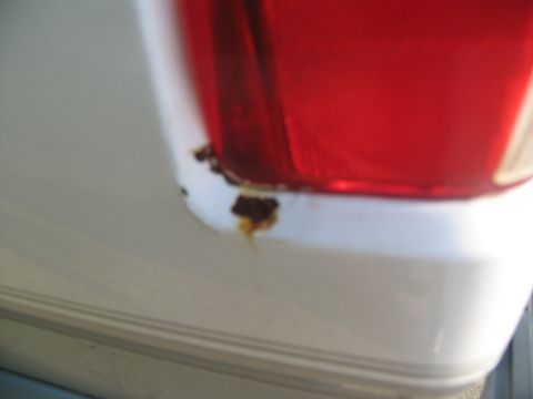 1995 Ford C-350 (Centurion Conversions) - Rust is visible beneath the red taillight assembly on the white body panel of a vehicle.