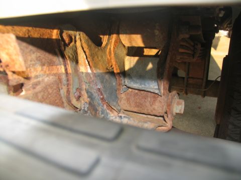 1995 Ford C-350 (Centurion Conversions) - Close-up view of heavily corroded vehicle frame and suspension components.