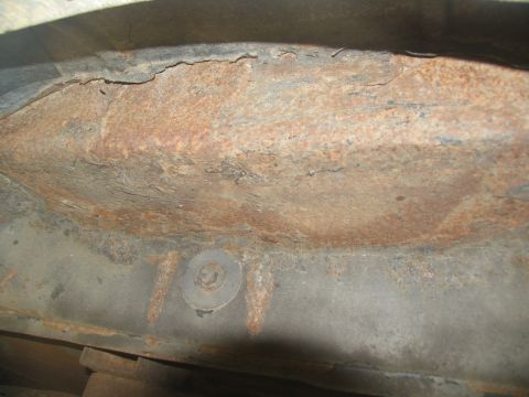 1995 Ford C-350 (Centurion Conversions) - Close-up view of significant rust damage on a vehicle's frame structure.