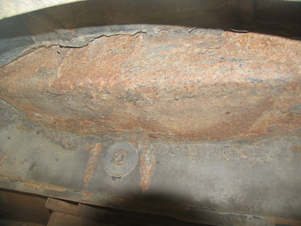 Heavily rusted metal frame section with a bolt and washer visible