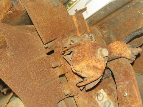 1995 Ford C-350 (Centurion Conversions) - Close-up view of heavily corroded vehicle frame components, showing significant rust and wear.