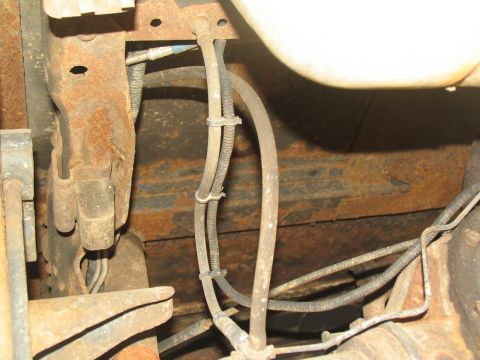 1995 Ford C-350 (Centurion Conversions) - Close-up view of the undercarriage, showing brake lines and a rusty frame.