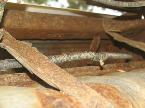1995 Ford C-350 (Centurion Conversions) - The vehicle's underbody shows extensive rust and corrosion on its structural components.