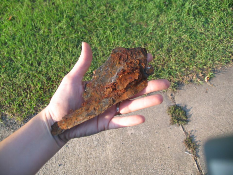 hand holding a heavily rusted metal piece