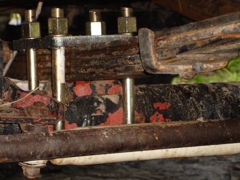 1989 Ford Bronco - Close-up of a leaf spring U-bolt plate, showing hardware and painted frame components.