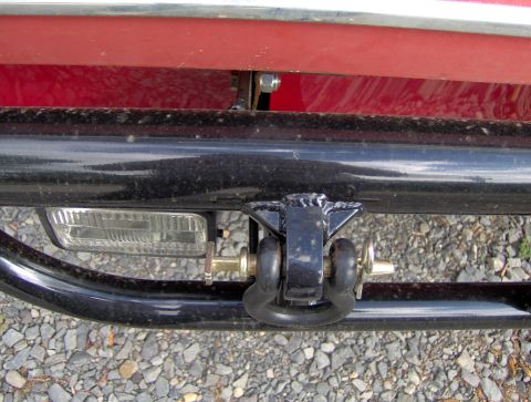 1978 Ford Bronco - Close-up of a trailer hitch assembly and a rectangular light on a vehicle's rear.