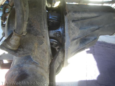 1987 Suzuki Samurai - Close-up of a damaged rear axle differential, revealing broken internal components and a brake line.