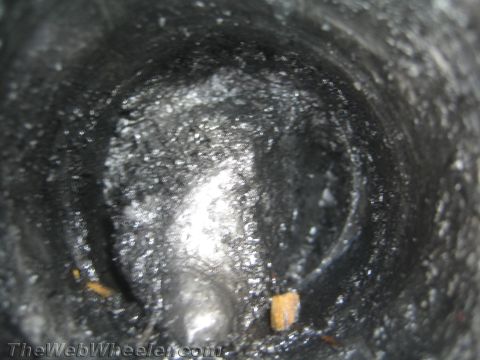 1987 Suzuki Samurai - The interior of a dark, possibly metallic, hollow object is shown with some debris.