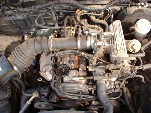 1993 Mitsubishi FTO - The engine bay of a 1993 Mitsubishi FTO is shown, with "MITSUBISHI" visible on a component.