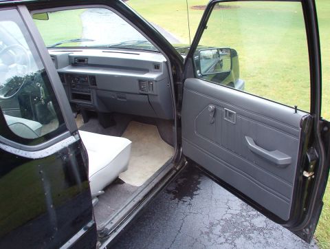 1993 Mitsubishi FTO - View of the interior of a black pickup truck, showing the dashboard, door panel, and seat.