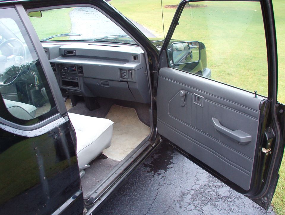 Interior of black pickup truck with gray door panel and white seat