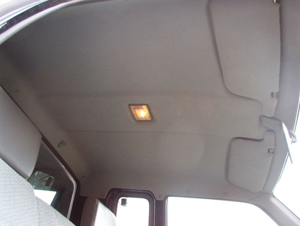 Vehicle interior ceiling with a light fixture and sun visors. A watermark reads SUPERMOTORS.NET