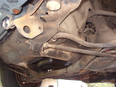 1993 Mitsubishi FTO - A close-up view of the vehicle's undercarriage reveals suspension parts and the exhaust system.