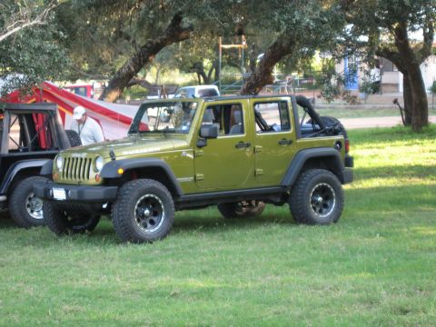 2001 Jeep Wrangler - Two Jeeps are parked on a grassy area with trees overhead.