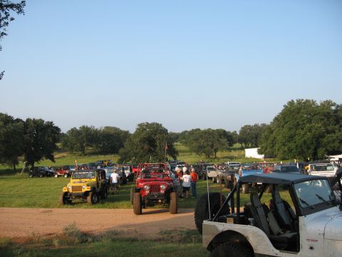 2001 Jeep Wrangler - A large group of Jeeps are parked in a field, with several people milling about.