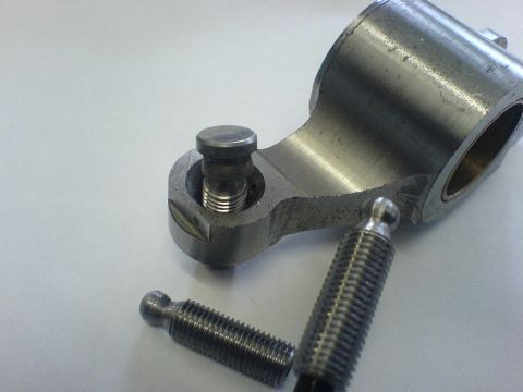 1964 Ford 427 - A detailed view of a metal engine component, possibly a valve train part, with visible threads and a SuperMotors watermark.