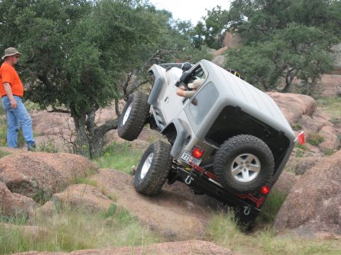 2001 Jeep Wrangler - A 2001 Jeep Wrangler navigates a challenging rocky terrain with a spectator observing the off-road adventure.