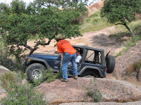 2001 Jeep Wrangler - A Jeep Wrangler is being guided over rocks by a trail guide.