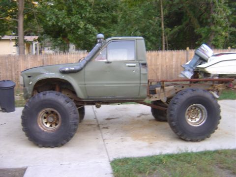1987 Suzuki Samurai - This modified pickup truck features a snorkel and oversized tires, suggesting off-road capabilities.