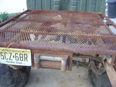 1987 Suzuki Samurai - A close-up view of a rusty, diamond-plate flatbed trailer with a New Jersey license plate.