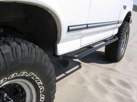 1991 Ford Bronco - Custom rock sliders installed on a 1991 Ford Bronco, with large off-road tires visible.