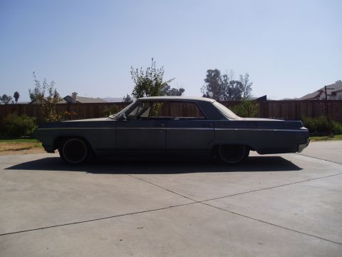 1964 Oldsmobile Delta 88 - Side profile of a 1964 Oldsmobile Delta 88 sedan parked on a concrete driveway.