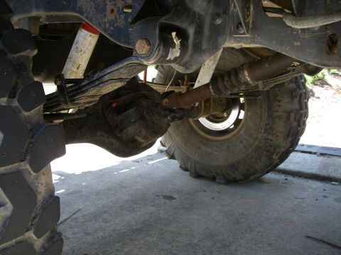 1995 Ford Bronco - Close-up view of the undercarriage, showing the rear axle assembly and suspension components of a vehicle.