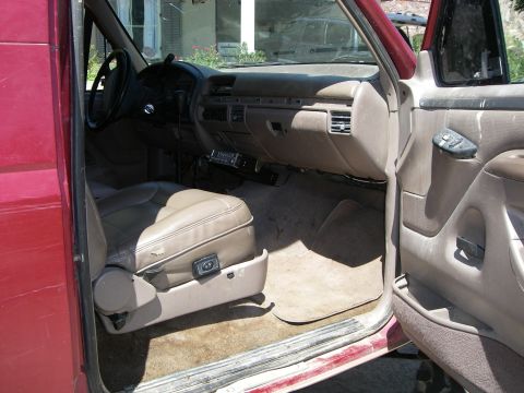 1995 Ford Bronco - Interior view of a red SUV, revealing tan leather seats and dashboard details.