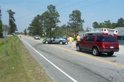 1998 Ford Crown Victoria - Emergency responders attend to a multi-vehicle accident scene on a two-lane road.